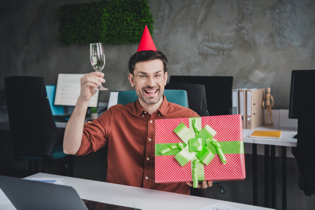 男人庆祝生日的照片礼盒吐司坐在桌子共同工作成功的商人穿棕色正装漂亮的创意光办公室图片下载