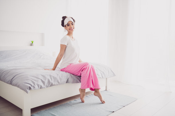 美丽的美国可爱的年轻女孩穿着睡衣的照片，早上醒来，早上好，舒适的卧室，室内有大床图片下载