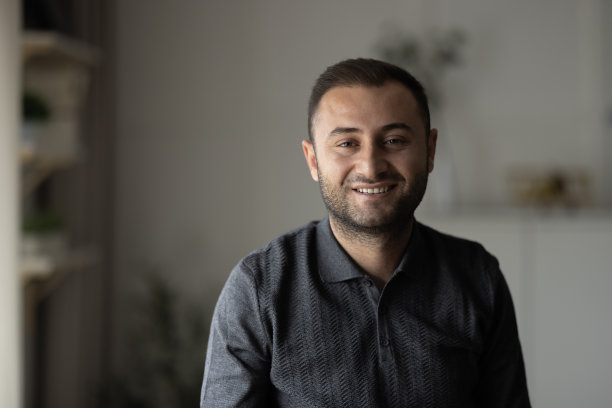 微笑的年轻人放松地坐在椅子上想象图片下载