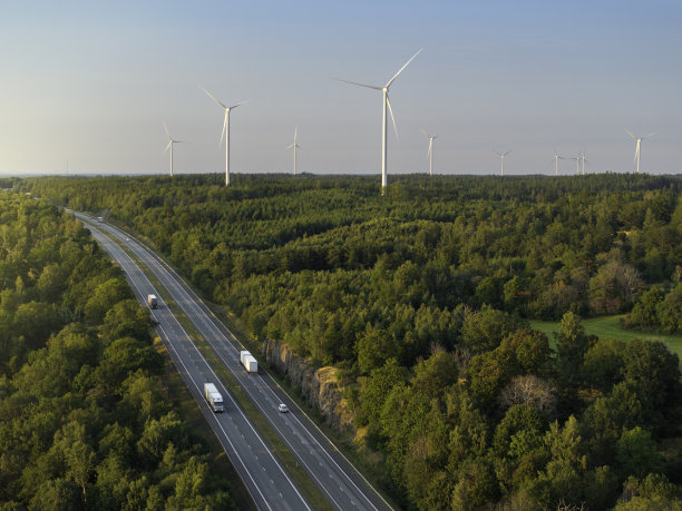 公路在森林景观与风力涡轮机图片下载