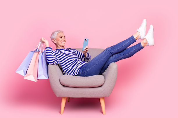 照片中迷人开朗的高级妇女穿着条纹时尚的衣服，在粉红色的背景上使秩序孤立图片下载