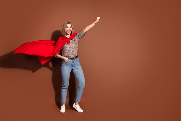 照片中时髦开朗的女人穿着格子时尚的衣服，在棕色的背景上飞空孤立图片下载