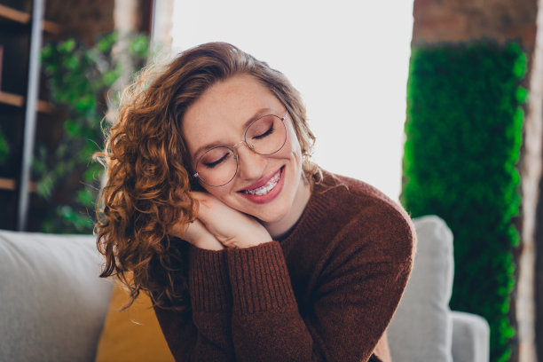 照片开朗可爱可爱的可爱的女人穿着时尚的套头衫，手摸脸在室内的房子图片下载