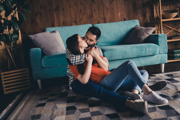 欢快可爱的年轻夫妇的全身照片坐在地板上享受周末玩得开心买新公寓在室内在家里图片下载