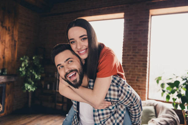 幸福的年轻夫妇的照片，拥抱背搬到新的地方，享受住在一起，有乐趣，新的公寓房间，灯光，房子，公寓，室内图片下载