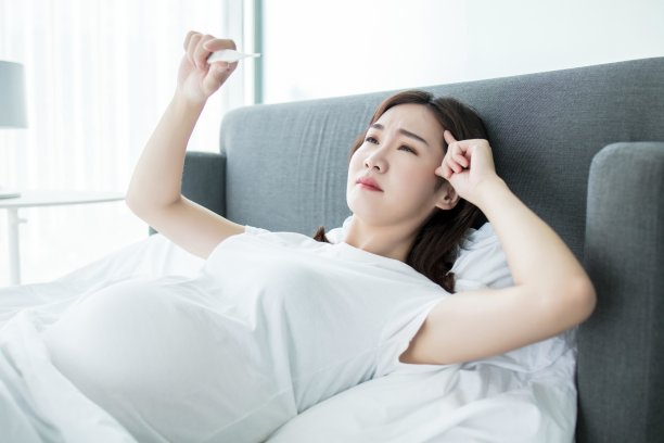 亚洲妇女躺在床上检查体温图片下载