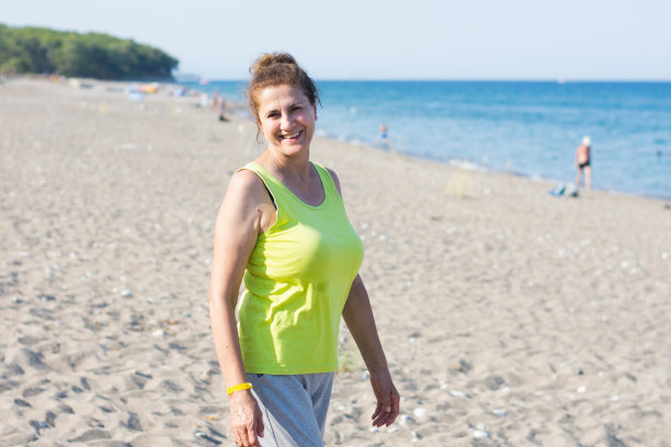 一个迷人的成熟的女人在海滩上享受一天的照片图片下载