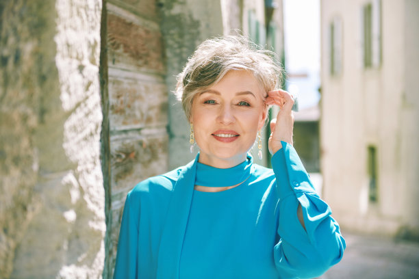 美丽的55 - 60岁妇女的时尚肖像在一个古老的欧洲城市的街道上摆姿势图片下载