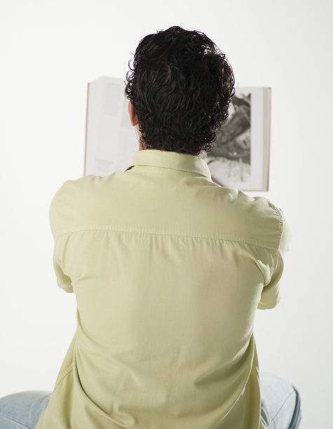 年轻人在白色背景下听着耳机读书图片下载