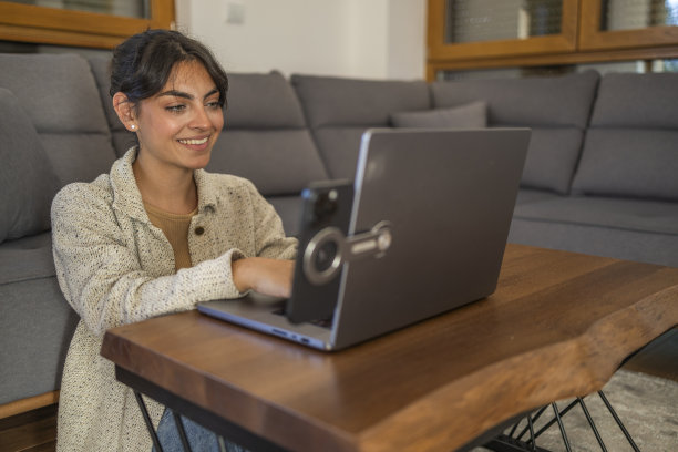 漂亮的女商人在家里开电话会议，打字和工作。图片下载