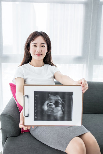 一名孕妇手持未出生婴儿的超声波扫描照片图片下载
