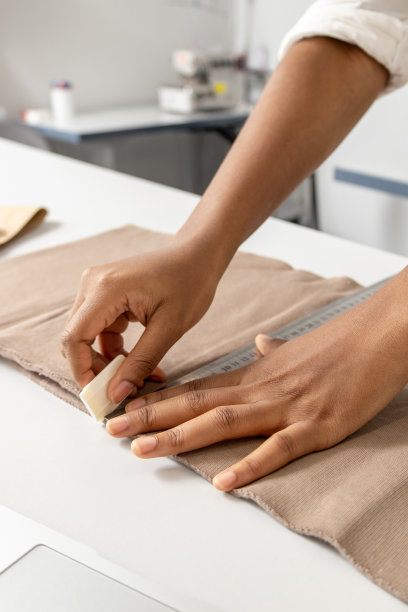 女裁缝用粉笔在布料上画出服装的图案图片下载