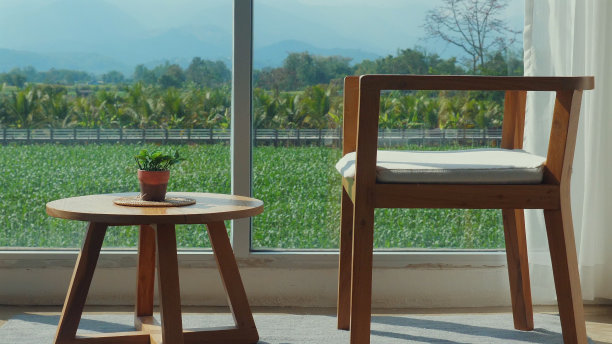 现代木椅和小桌子，大窗边有植物图片下载