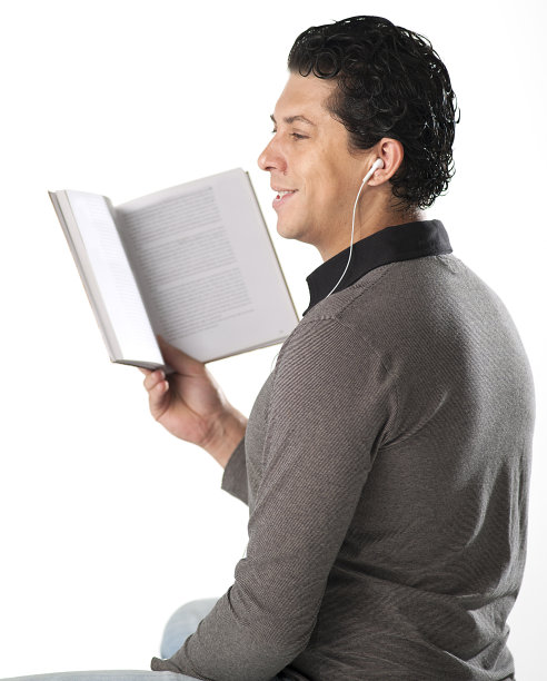 年轻人在白色背景下听着耳机读书图片下载
