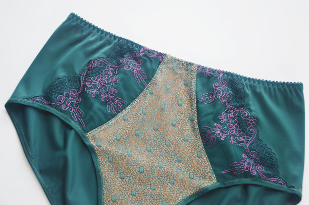 女人的内衣。白色背景上有蕾丝元素的绿色内裤。时尚女士内衣。图片下载