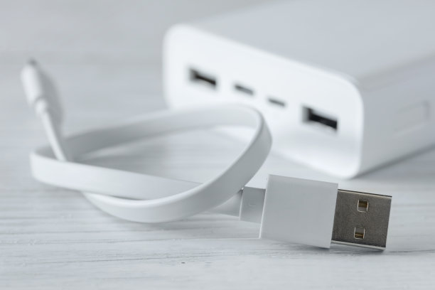 白色移动电源，为智能手机和各种数字设备充电，白色木制背景图片下载