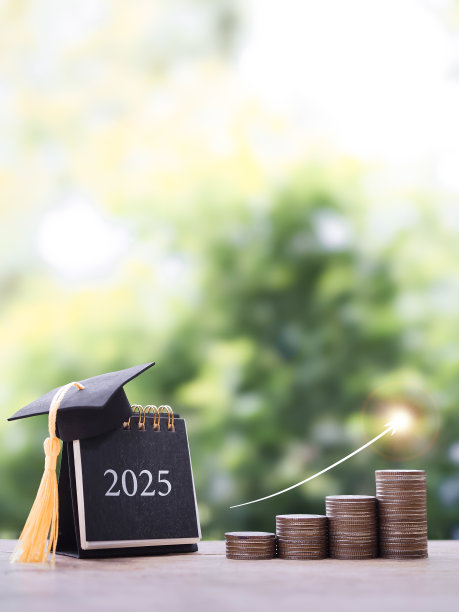 2025台历有毕业帽，一堆硬币和上升的箭头。为2025年的教育、学生贷款、奖学金、学费存钱的概念图片下载