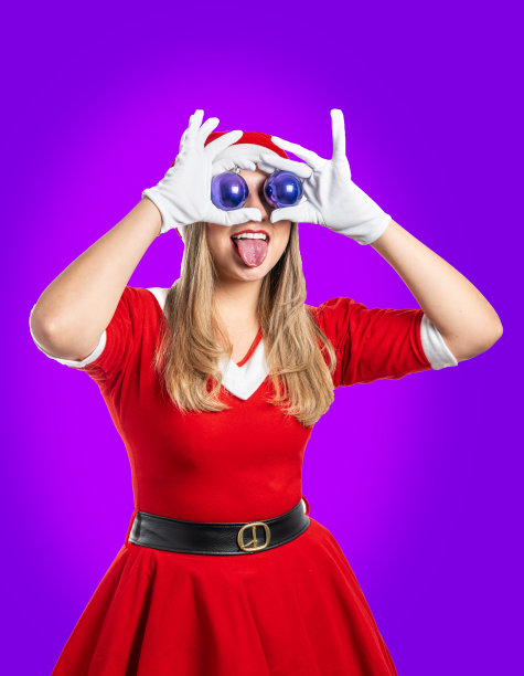 年轻的金发妈妈克劳斯伸出舌头，把两个圣诞球放在她的眼睛上图片下载