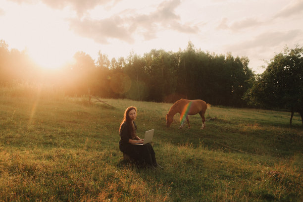 在生态农场外使用笔记本电脑的妇女。在线聊天。把空闲时间花在大自然上。概念在家工作，慢生活，保持联系，社交距离，互联网。本系列的一部分图片下载