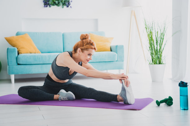 照片中的女性穿着运动服在室内做体育锻炼图片下载