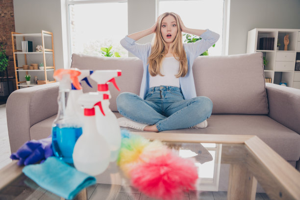 照片中的女孩穿着蓝色衬衫在房子里做家务图片下载