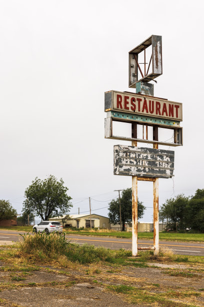 破产了。在俄克拉荷马州布莱恩县的乡村环境中，风化的餐馆标志被遗弃了图片下载