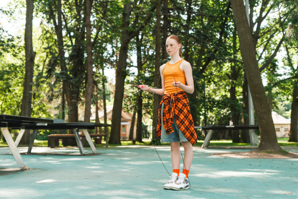 可爱的红发少女在公园跳绳图片下载