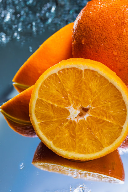 在一个反射表面上的整个和切片橙子的极端特写-库存照片图片下载