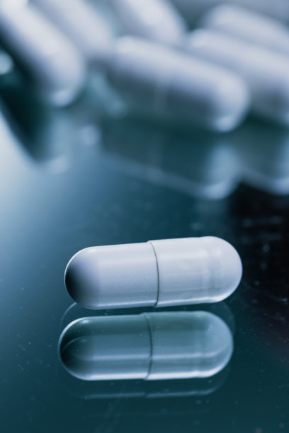 反光表面的白色胶囊-药物药丸特写-库存照片图片下载