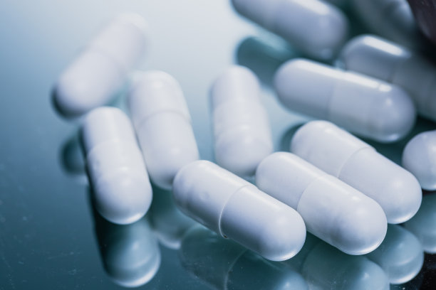 反光表面的白色胶囊-药物药丸特写-库存照片图片下载