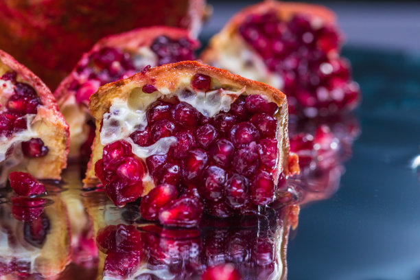 极端特写切片石榴在一个反射表面-库存照片图片下载