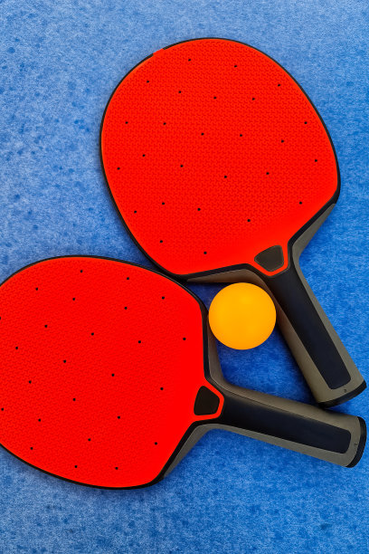 红色乒乓球拍和橙色球在蓝色乒乓球背景。前视图。图片下载