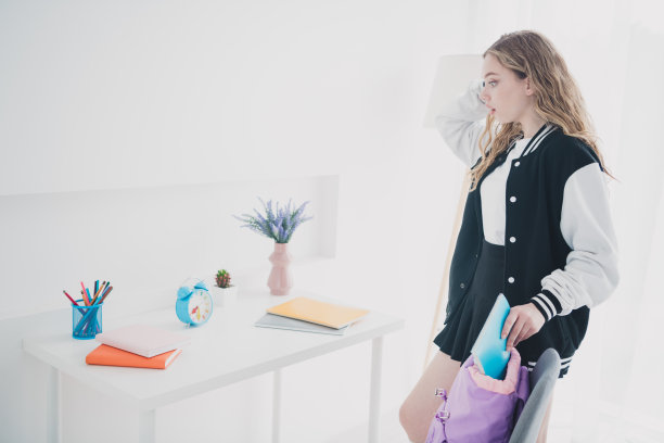 甜美可爱的少女肖像晚看时钟紧张穿时髦的校服准备卧室灯室内房子室内图片下载