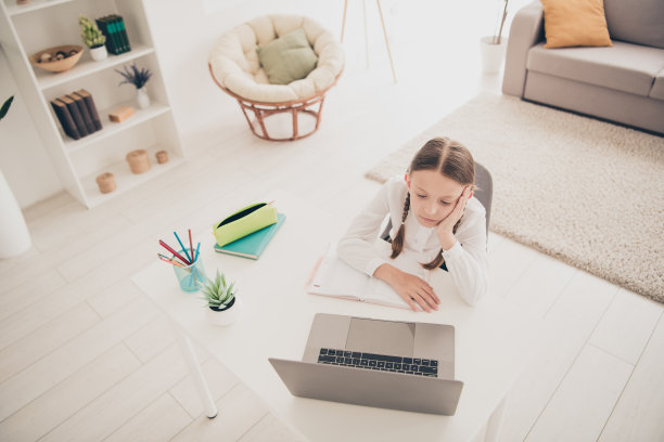 高角度看照片可爱的小女孩学习网上笔记本电脑书桌现代公寓室内图片下载