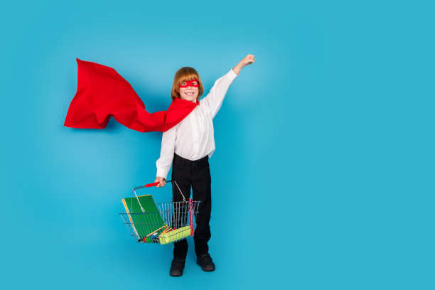 小学生的全尺寸照片，男孩的商店篮子飞空空间，穿制服孤立在蓝色的背景图片下载