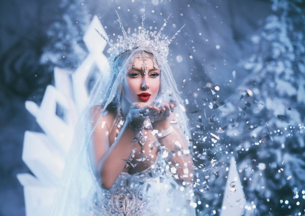 艺术照片幻想女人雪女王吹上闪闪发光闪闪寒冷创造魔法在森林白色礼服皇冠冰柱。童话女孩冰冻公主夫人冬天自然森林树木冰雾图片下载