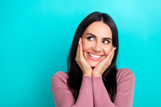梦幻般的年轻女孩的特写照片，触摸脸颊，黑发，看模拟广告购物戴森电子隔离在海蓝宝石的颜色背景图片下载