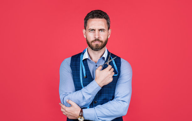 熟练的工匠裁缝用卷尺、剪刀进行制衣、剪裁图片下载