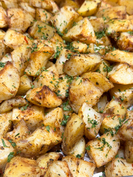 整幅图片，一堆脆脆的香草和香料土豆，新鲜煮熟的，切丁的，香草烤土豆，在酒店自助服务的食物，高架视图图片下载