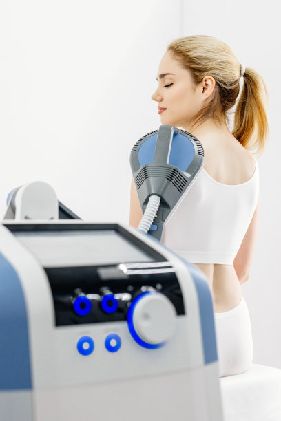 理疗师使用先进设备进行电磁疗法治疗背痛，展示有效的疼痛管理和康复技术图片下载