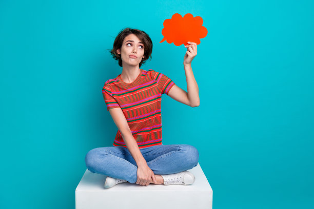 照片上失望悲伤的女孩穿着时髦的衣服，手拿纸海报，在青色的背景上看起来空无一物图片下载