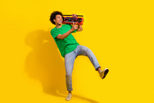 开朗积极的家伙全身照片穿着绿色t恤跳舞听立体声音乐空旷的空间孤立的黄色背景图片下载