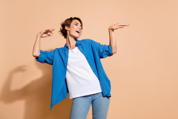 照片的年轻放松的女士在蓝色衬衫跳舞布吉伍吉她的最后一天工作坏公司孤立的米色背景图片下载