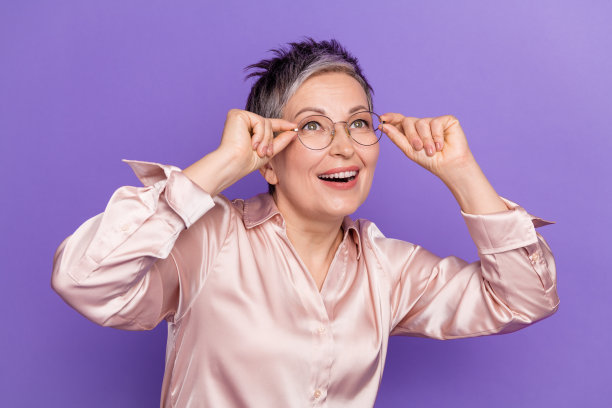 可爱的高级女士的照片肖像触摸眼镜看空空间穿着时尚的缎面服装孤立的紫罗兰色背景图片下载