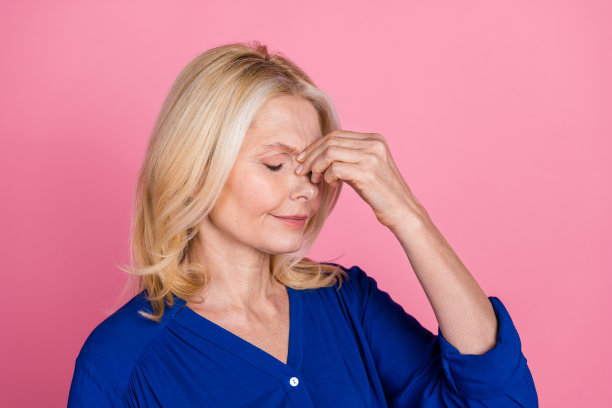 可爱的退休女士偏头痛的照片肖像穿着时尚的蓝色服装孤立在粉红色的背景图片下载