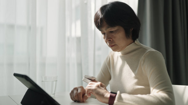 一个成熟的女人在家里检查自己的健康状况。图片下载