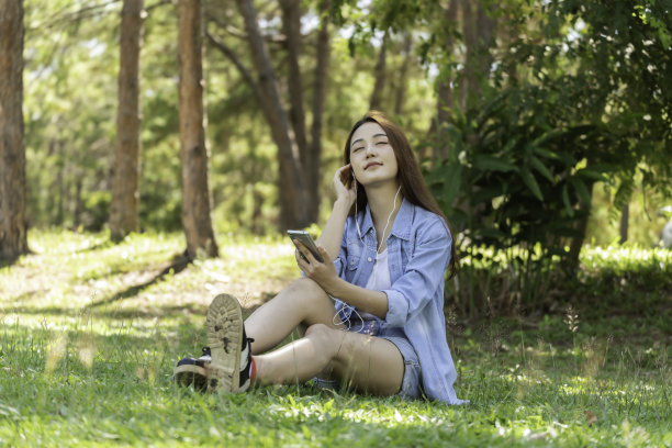 女人们在美丽的后院拿着手机和平板电脑。图片下载