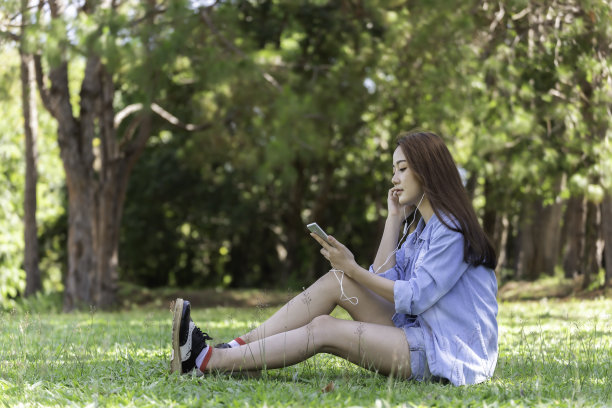 女人们在美丽的后院拿着手机和平板电脑。图片下载