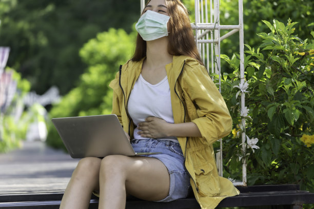 亚洲女商人在工作时有严重的腹痛，孤立的背景，手放在胃上，因为恶心，疼痛的疾病感觉不舒服。疼痛的概念。图片下载