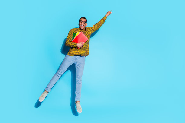 漂亮的年轻男性的全尺寸照片挂空空间拿抄写本穿时髦的格纹服装孤立在蓝色的背景图片下载